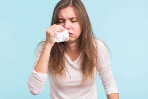 donna con naso che cola e fazzoletto