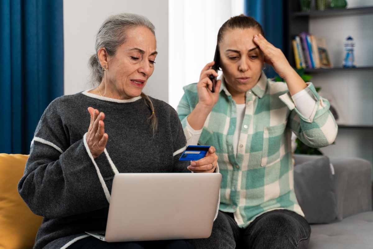 donna a telefono, donna con pc e carta di credito in mano visibilmente preoccupate